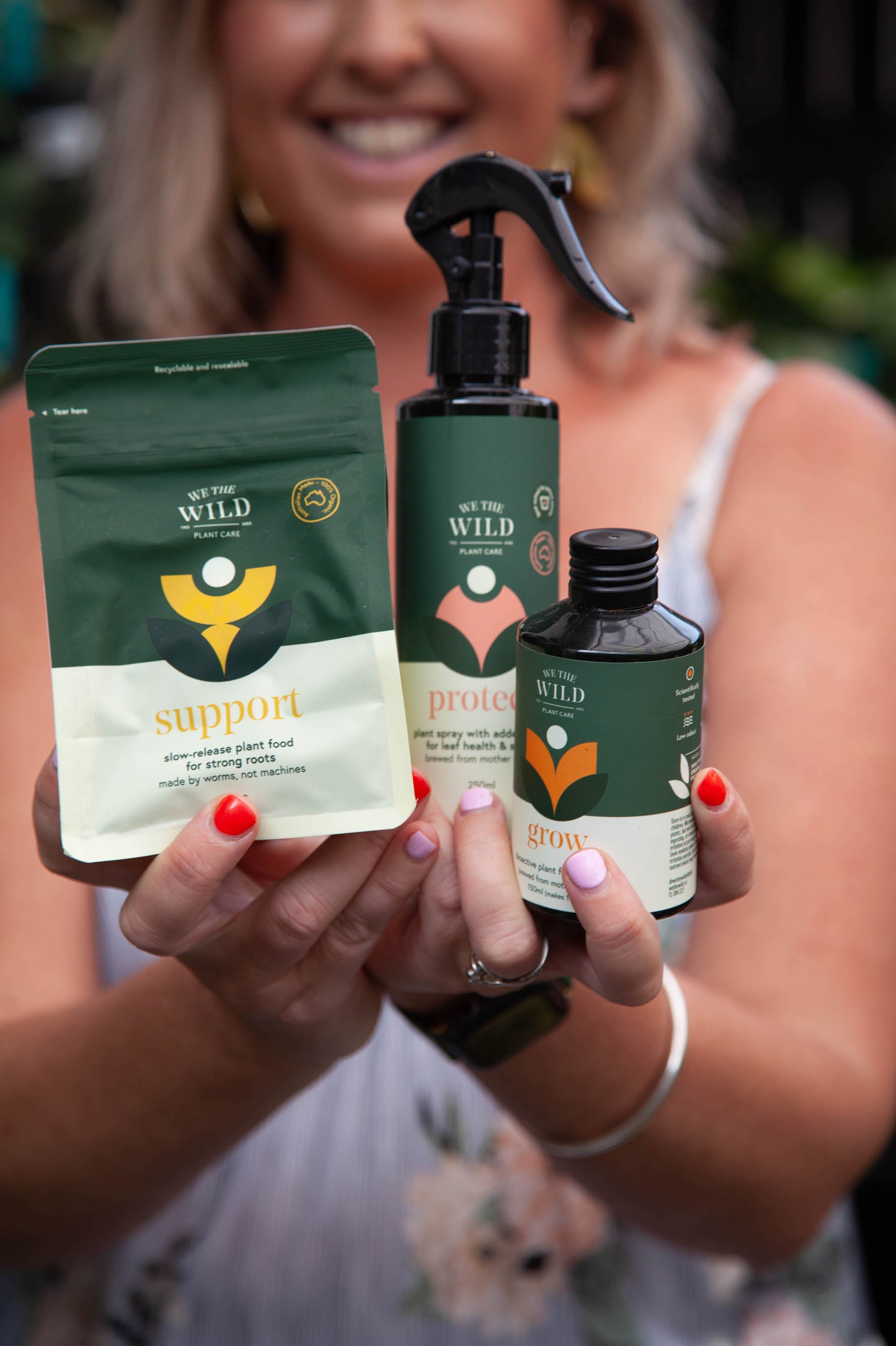 Holding plant care products Support Pellets, Protect Spray and Grow Plant food.